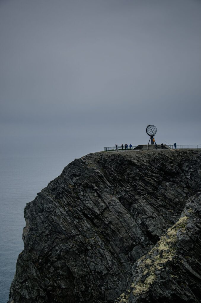Metal globe and people on Nordkapp