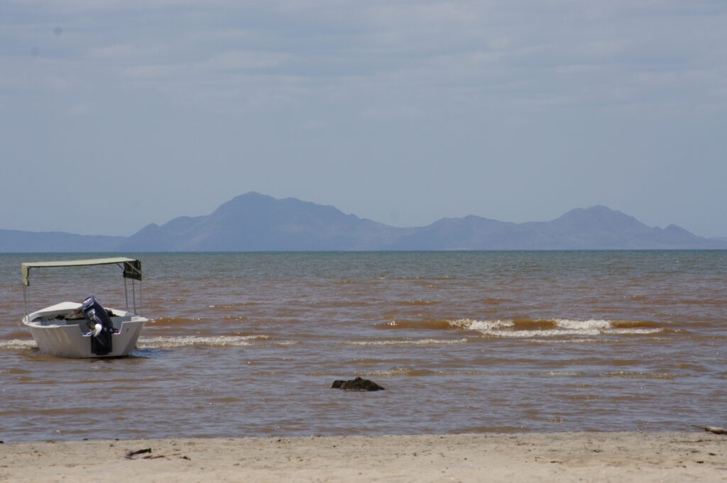 Lake, beach and mountains where there are boats, Lake Turkana in Kenya